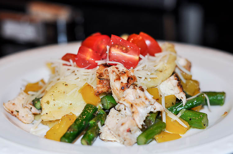 Chicken ravioli with tomato pepper and asparagus