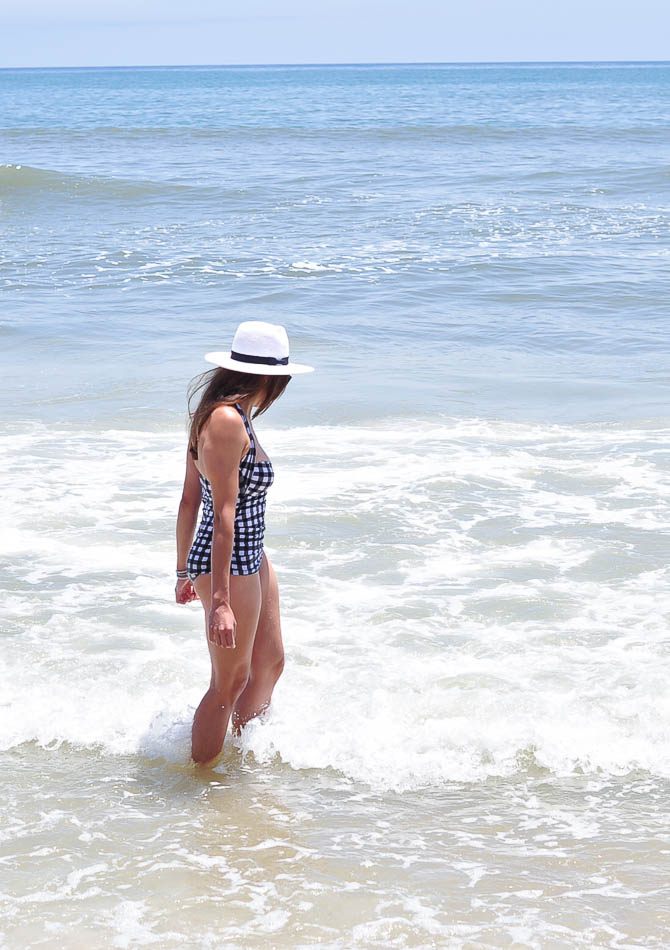 woman wearing LOFT Gingham one-piece swimsuit side view at Daytona beach