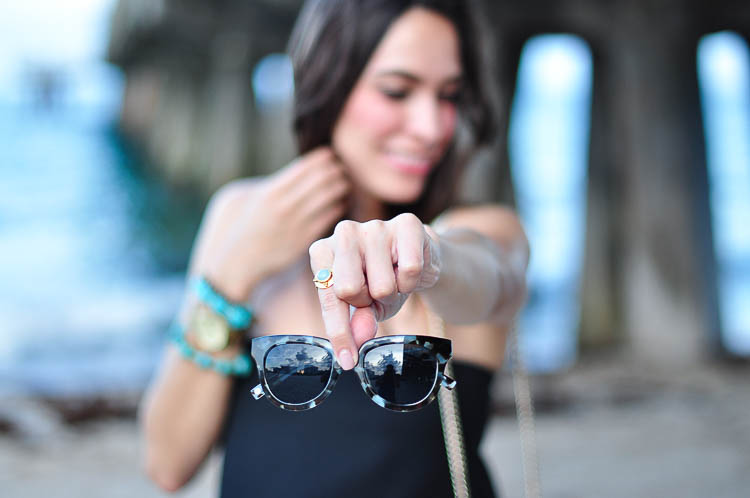 A Glam Lifestyle holding Warby Parker Banks graphic sunglasses 