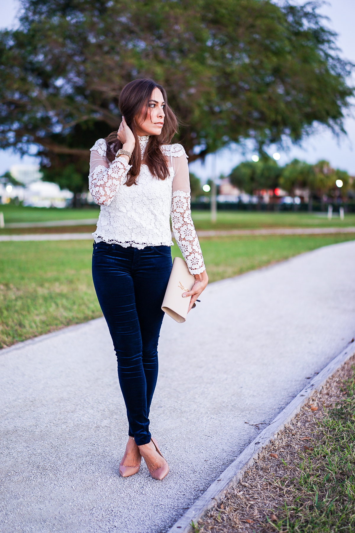 A Glam Lifestyle blogger wearing AG velvet legging jeans with Chicwish lace blouse and YSL monogram clutch