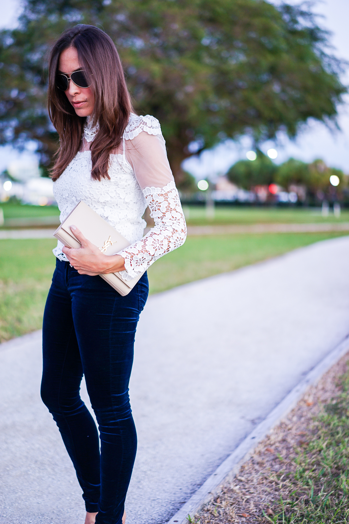 A Glam Lifestyle blogger wearing velvet legging with Chicwish white blouse and YSL monogram clutch