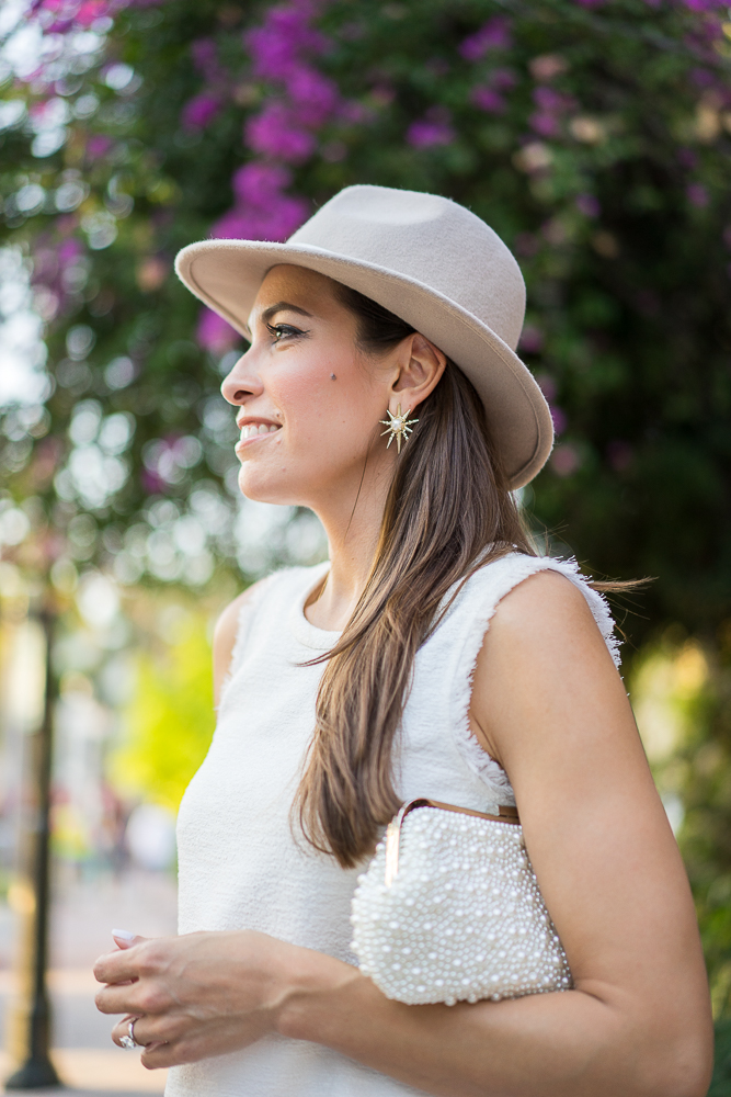 A Glam Lifestyle Blogger Amanda Champion showing her Pearl clutch and Kendra Scott Rogan stud earrings in gold
