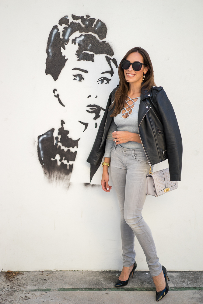A Glam Lifestyle Blogger Amanda Champion in a grey Sheinside lace up bodysuit, pants and Maje leather moto jacket