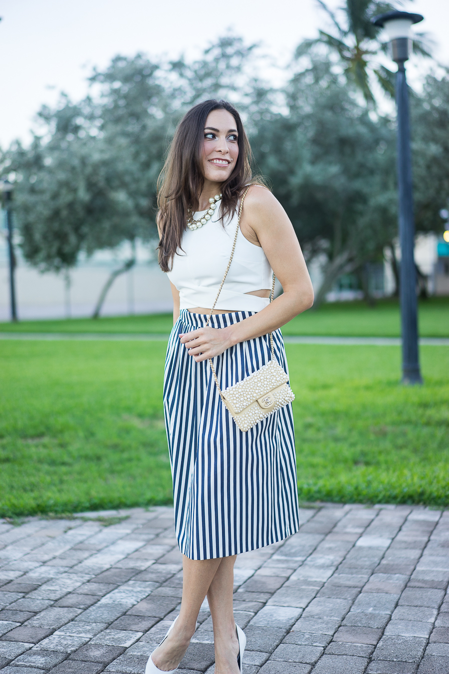 White crop top, striped skirt, Chanel pearl bag