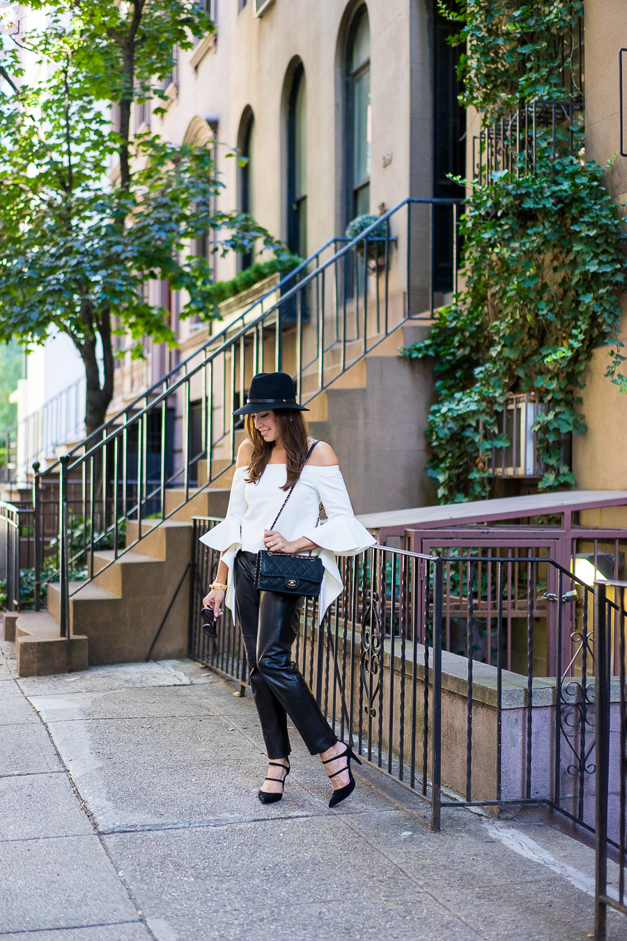 A Glam Lifestyle blogger wearing chicwish white off-the-shoulder top with milly black leather cropped pants and classic chanel bag with a rag and bone fedora and strappy-black-sandals