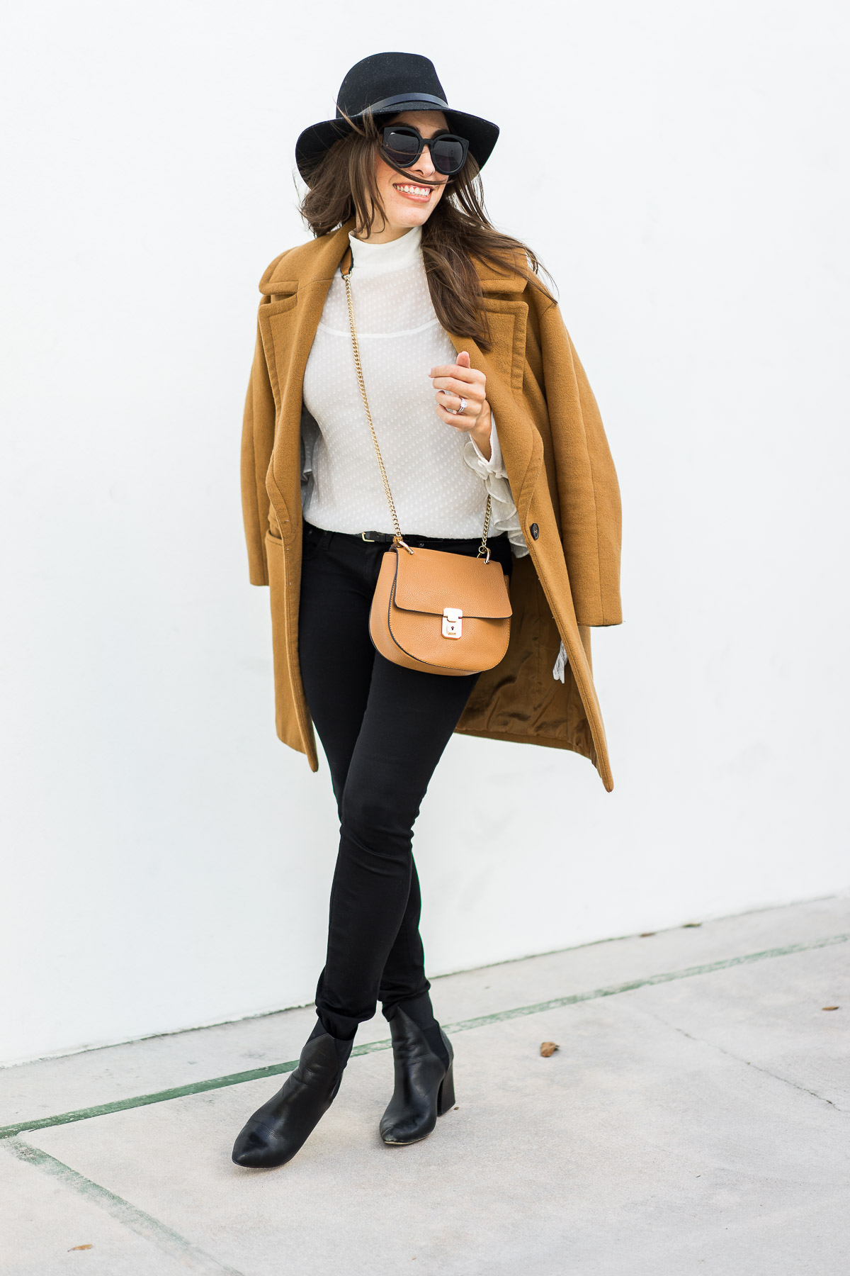 Amanda from A Glam Lifestyle wears oversized lapel camel coat by Zara with sheer white blouse by Chelsea28 and Chloe Drew dupe bag