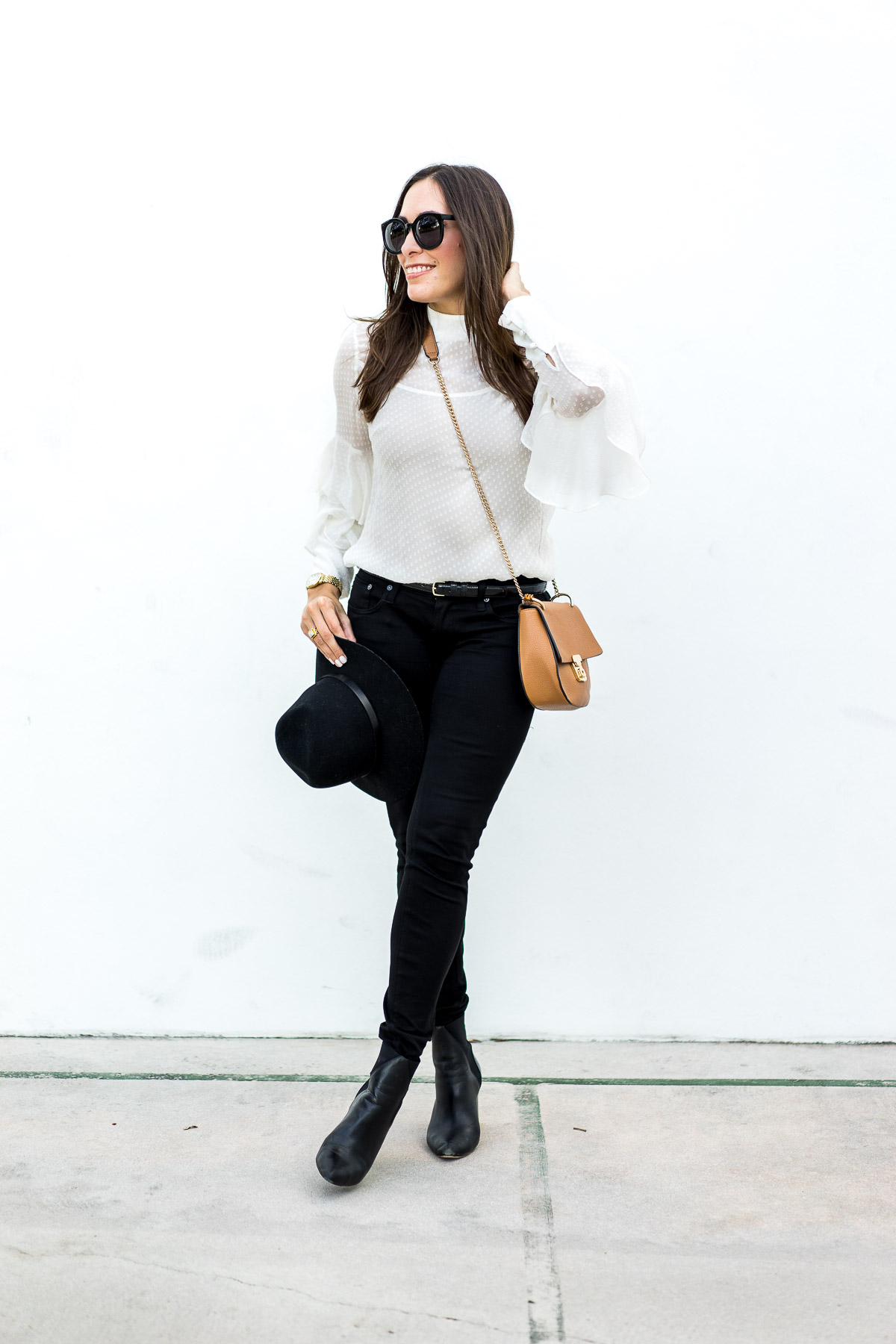 Amanda from A Glam Lifestyle wears sheer white blouse and accesorizes with Rag and Bone black fedora and Chloe drew bag dupe