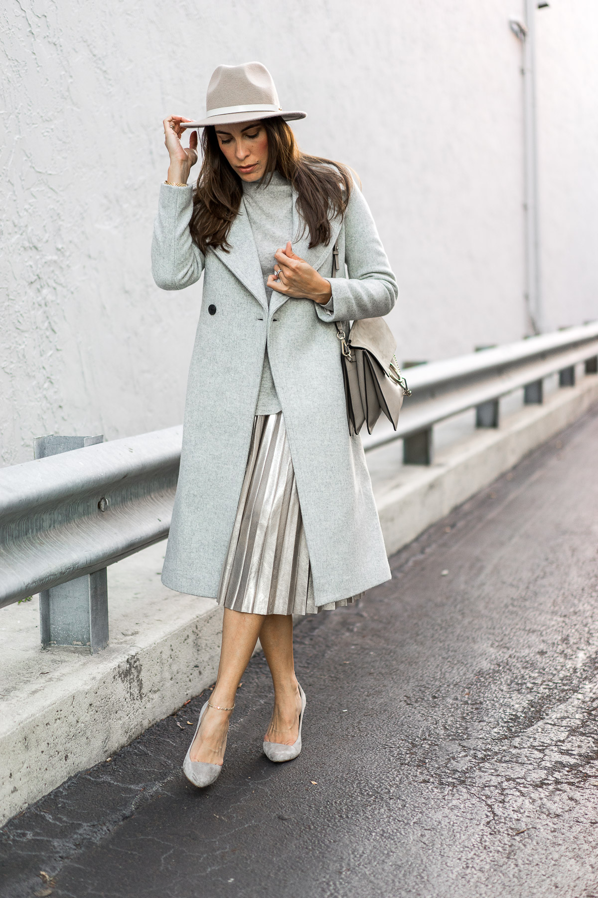 Blogger A Glam Lifestyle showcases her winter style in Club Monaco Daylina coat with gold metallic midi skirt and grey suede Madewell pumps