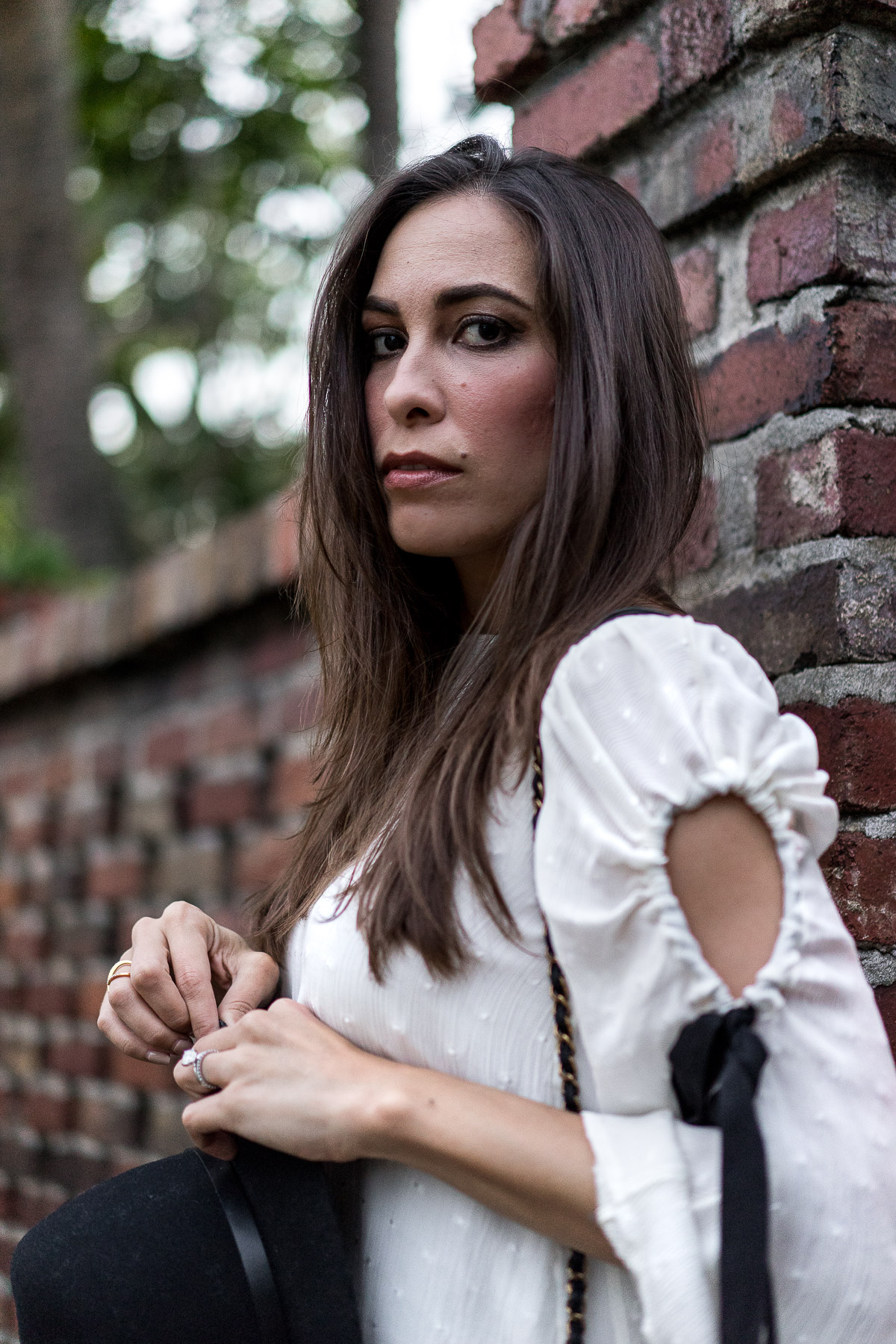 Amanda from A Glam Lifestyle blog wears Club Monaco bell sleeve top called Priyalla top with black ribbon tie sash