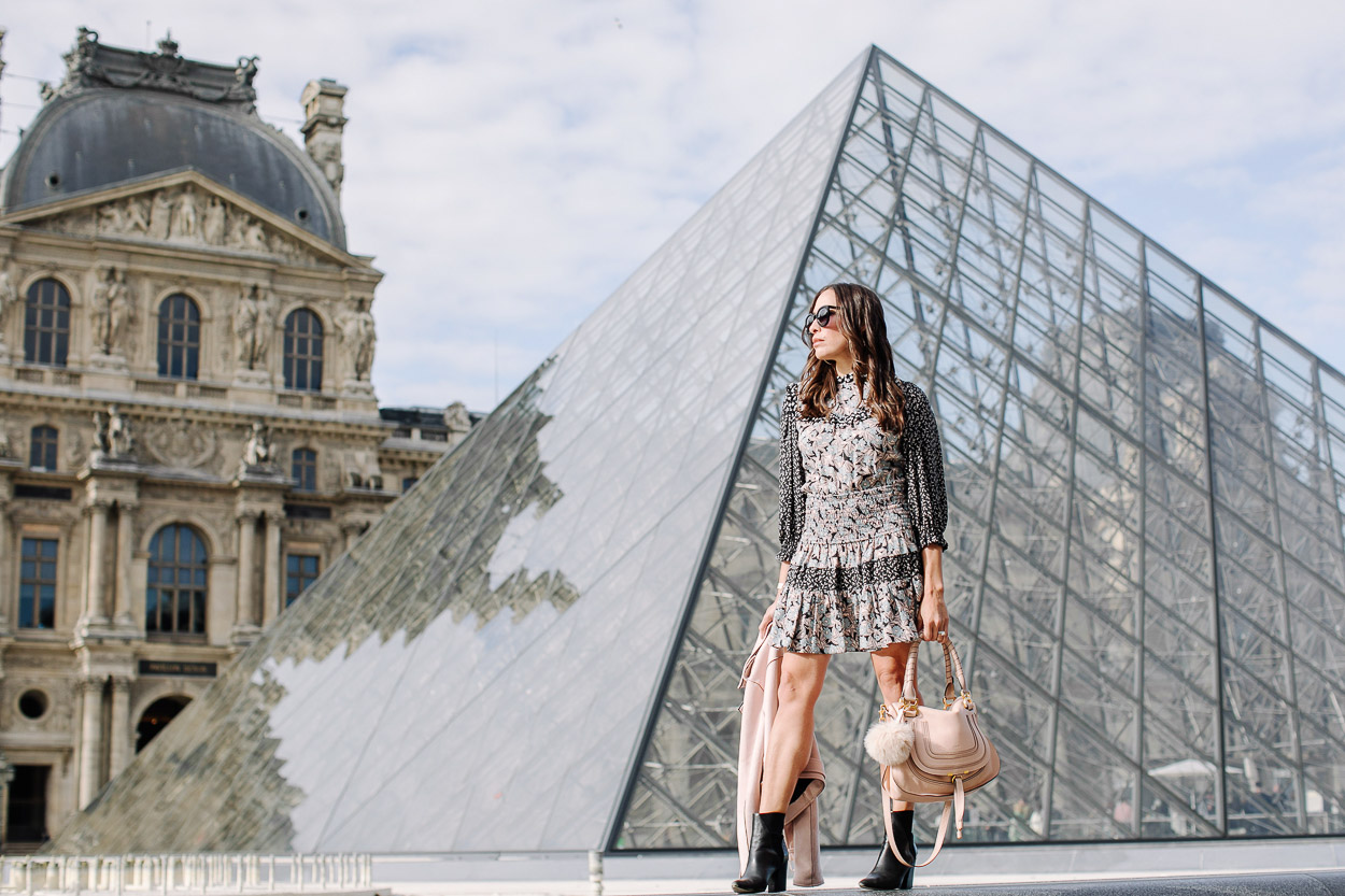 Fashion blogger Amanda wears silk floral dress at the Louvre during Paris vacation with black ASKA booties and blush moto jacket and Chloe Marcie bag