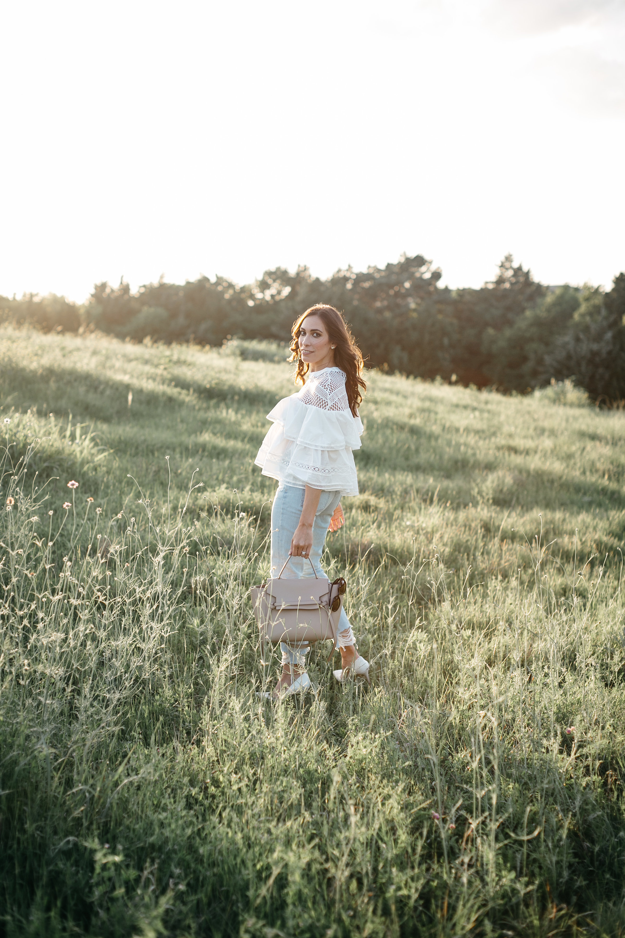 White tiered ruffle top styled by AGlamLifestyle blogger Amanda with Celine belt bag and Lovers and Friends distressed denim