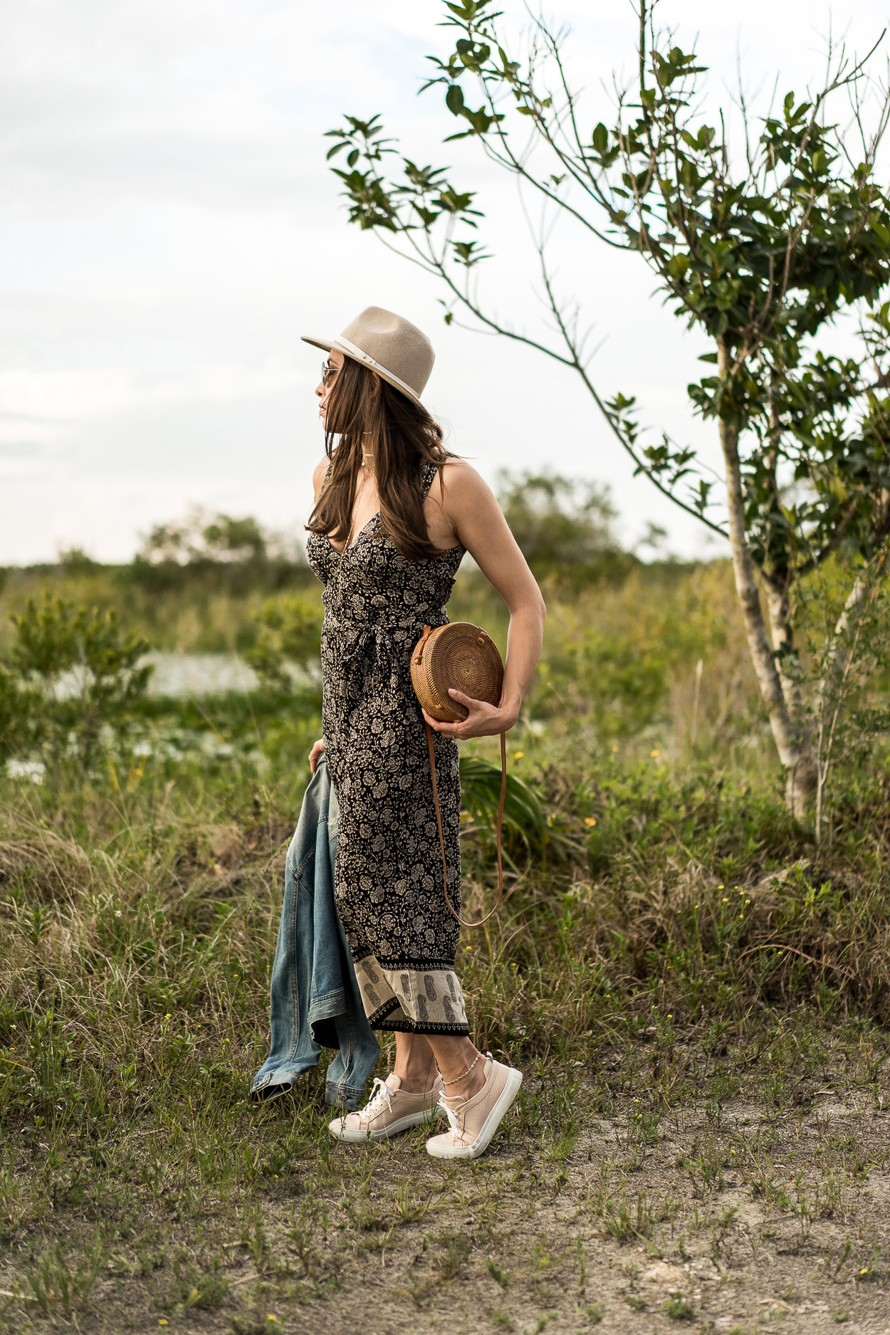 Boho style is so trendy for Summer like this Amuse Society jumpsuit Amanda of A Glam Lifestyle blog wears with chic accessories like round basket bag and MGemi Palestra sneakers