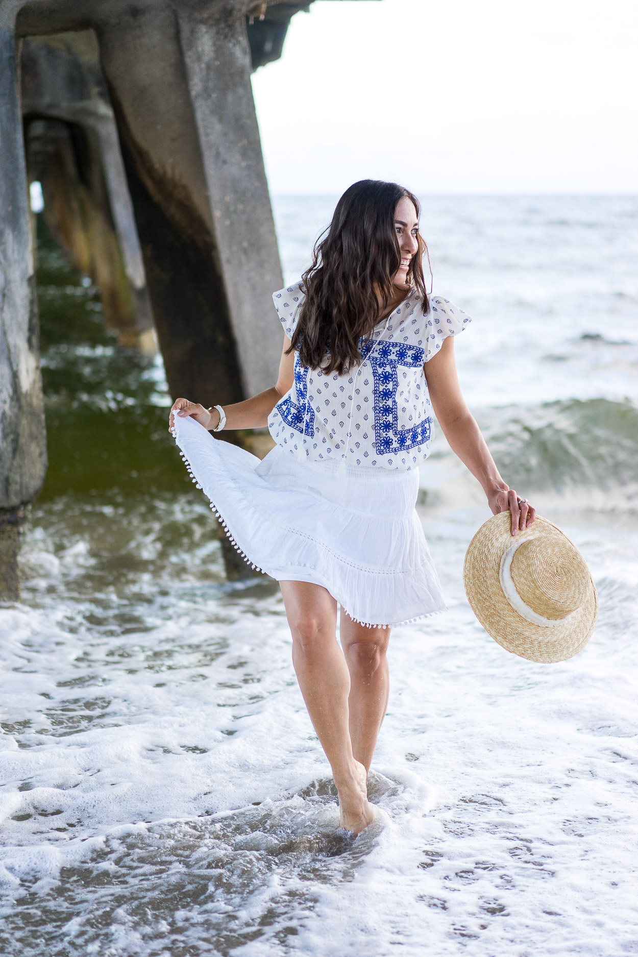 Blogger picks from Old Navy Summer favorites include pom pom skirt and white embroidered shirt with straw boater hat for beach style