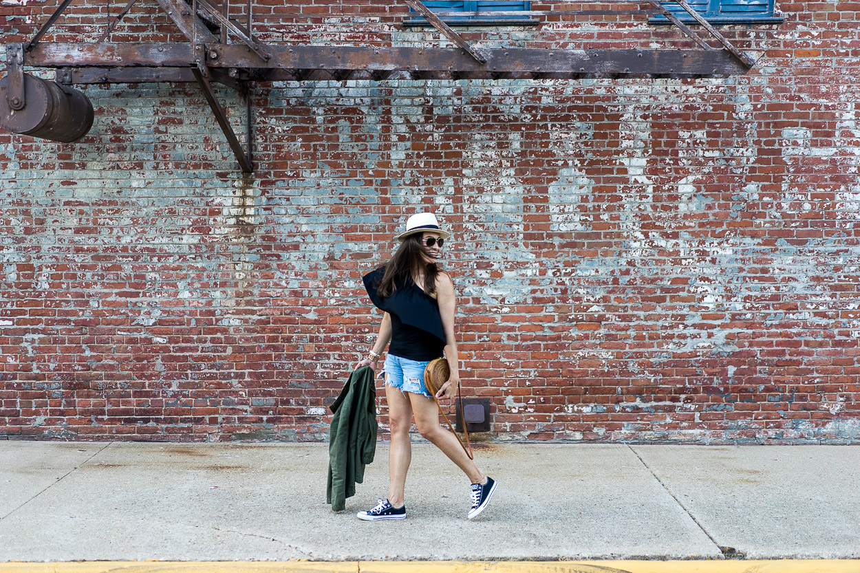 Blogger AGlamLifestyle wears Three Dots black one shoulder top with Rag & Bone denim cutoff shorts and Old Navy utility jacket in Illinois