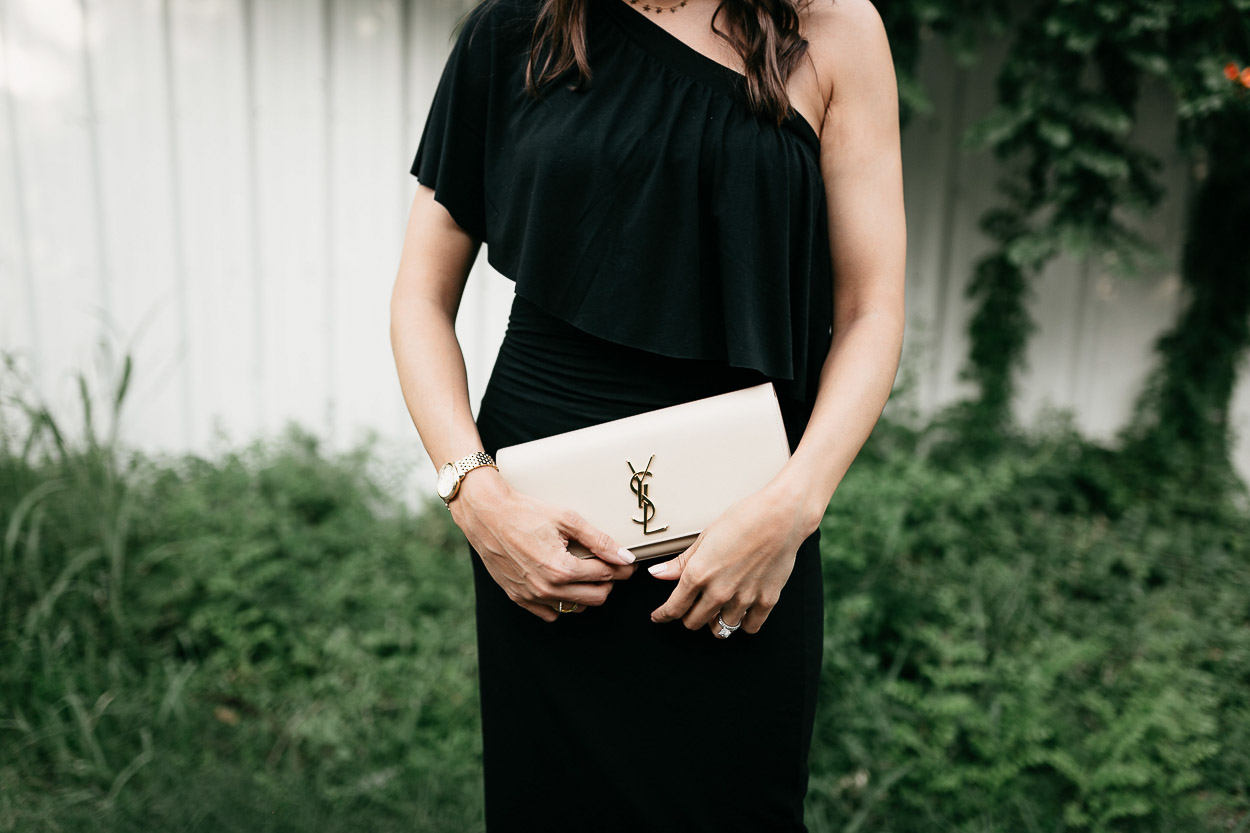 A classic YSL monogram clutch pairs easily with Three Dots black ruffle dress for date night