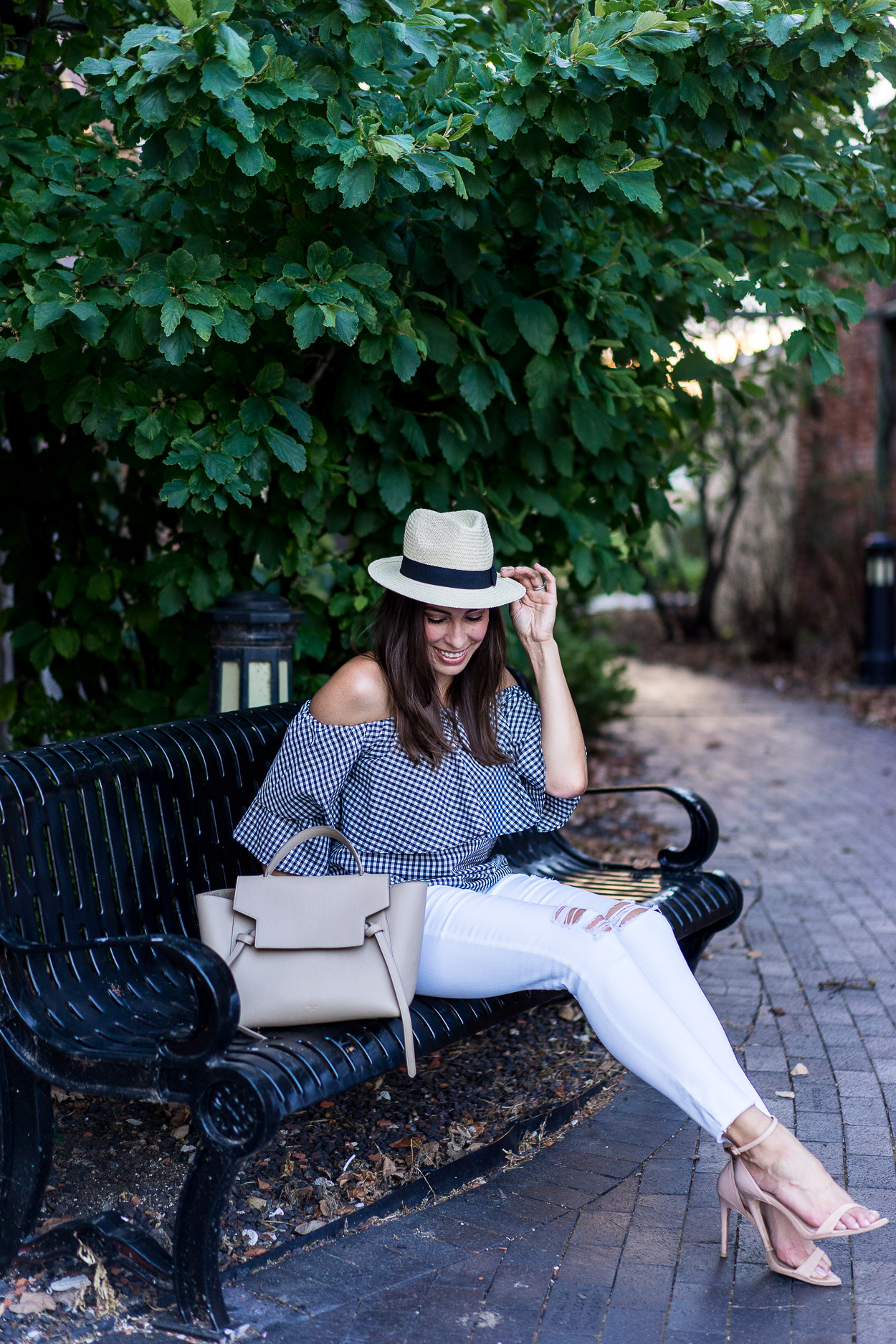 Amanda of A Glam Lifestyle blog wears Wayf gingham top with white distressed AG jeans and Celine belt bag for Fall transitional style