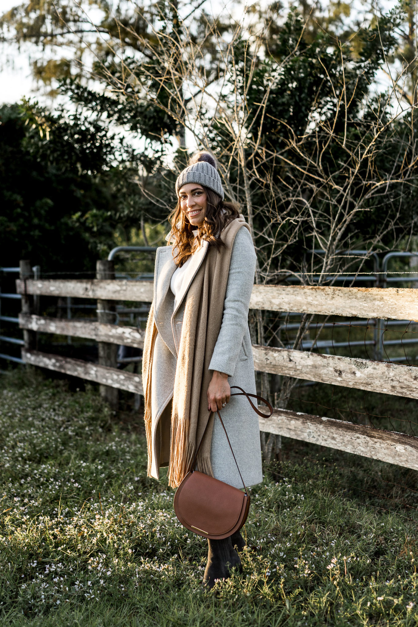 Amanda carries her Cuyana leather saddle bag and wears her Club Monaco Daylina coat