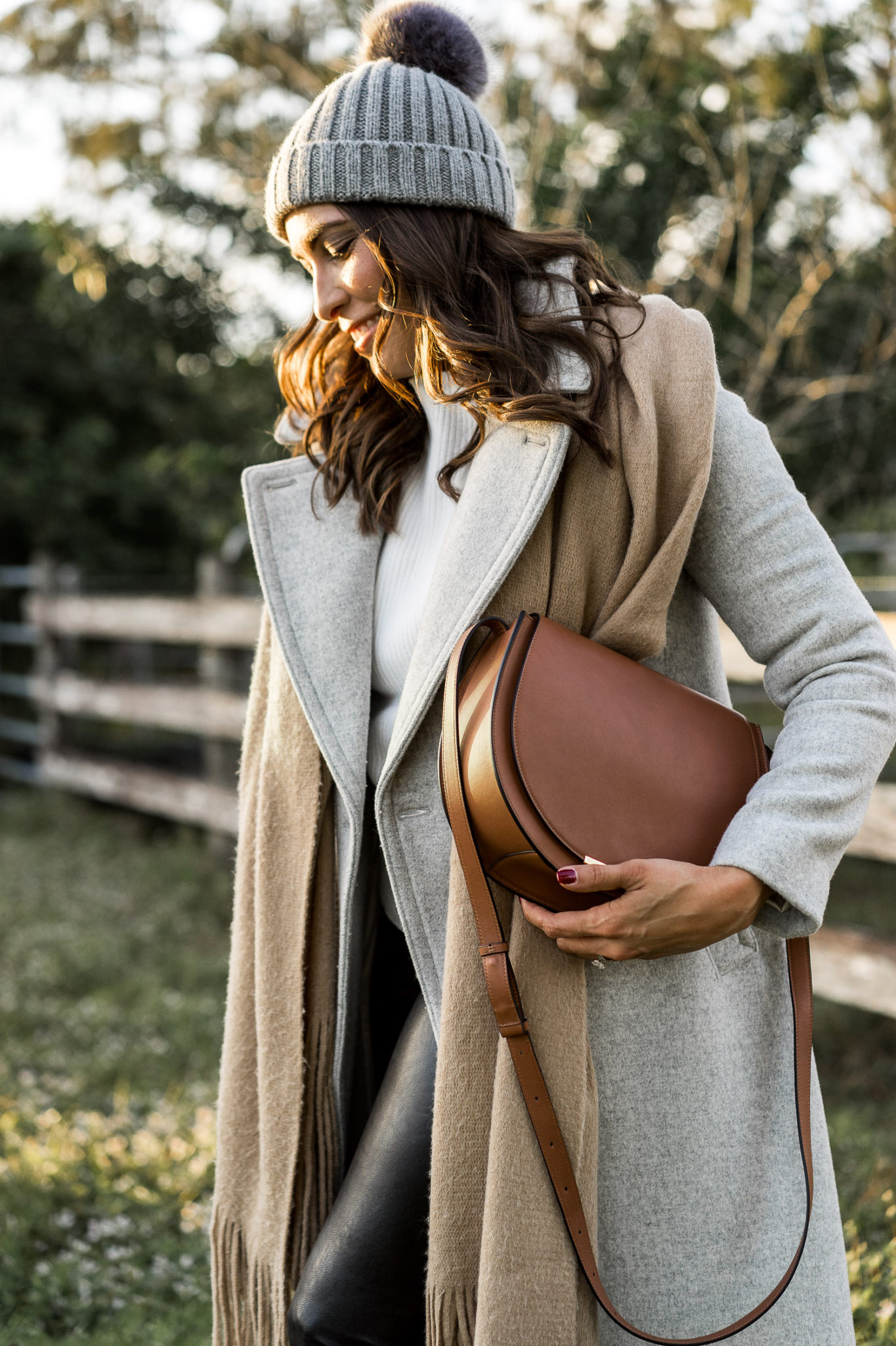 Amanda carries her Cuyana bag while walking towards the Maserati Levante