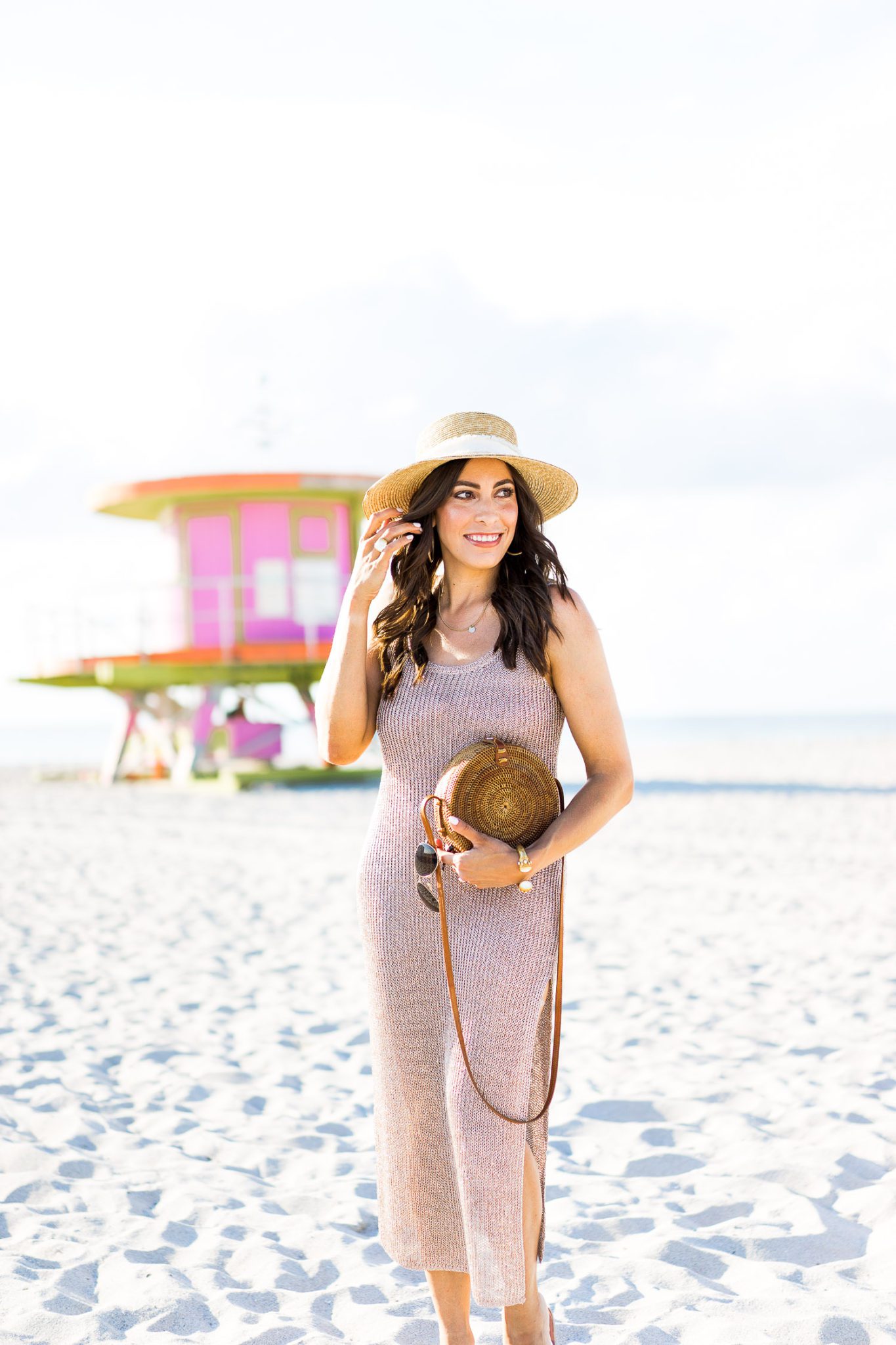 Beach Coverups by popular Florida fashion blog, A Glam Lifestyle: image of a woman walking on the beach and wearing a straw sun hat and Lovers + Friends Fiona Dress. 