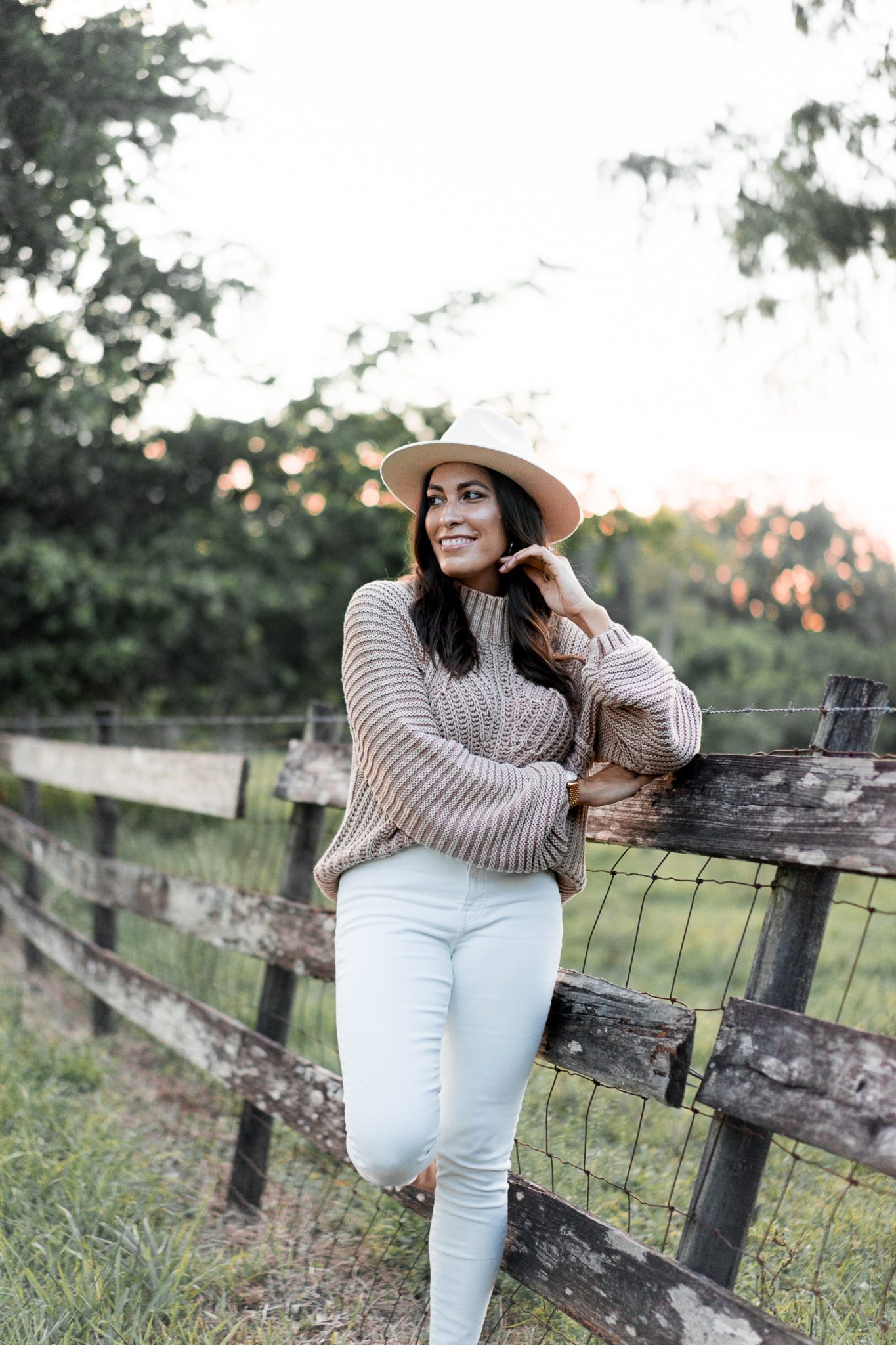 woman wearing hat, pants, and sweater for winter capsule wardrobe