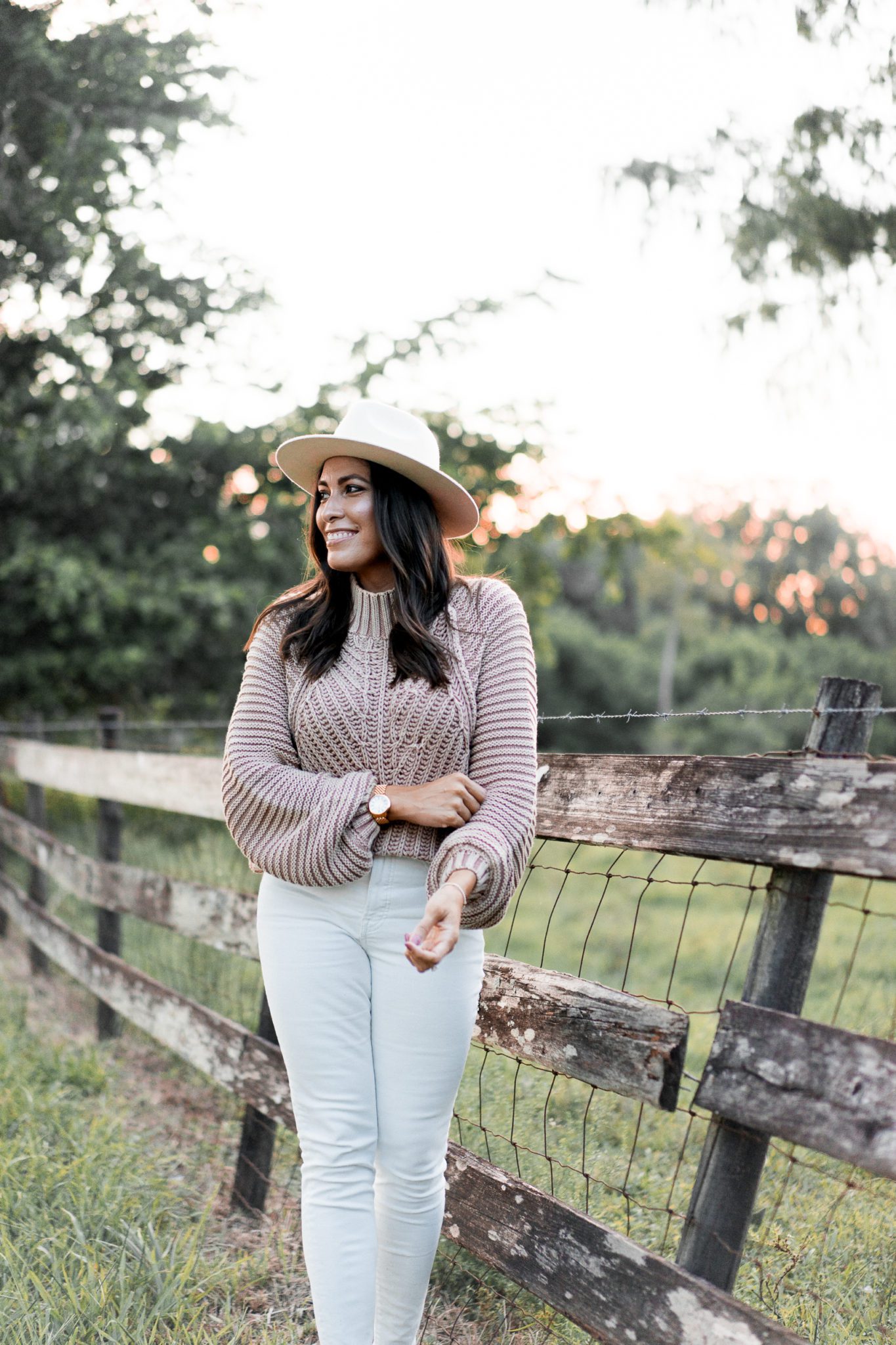 woman wearing hat and sweater for winter capsule wardrobe